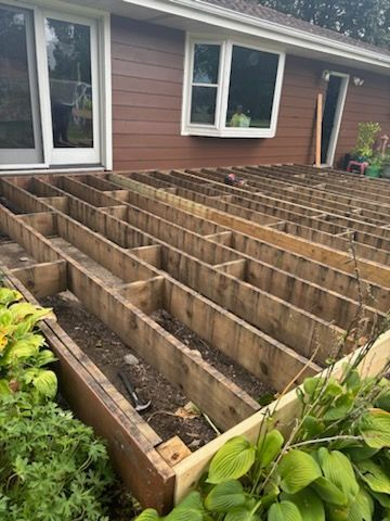 A wooden deck is being built in front of a house