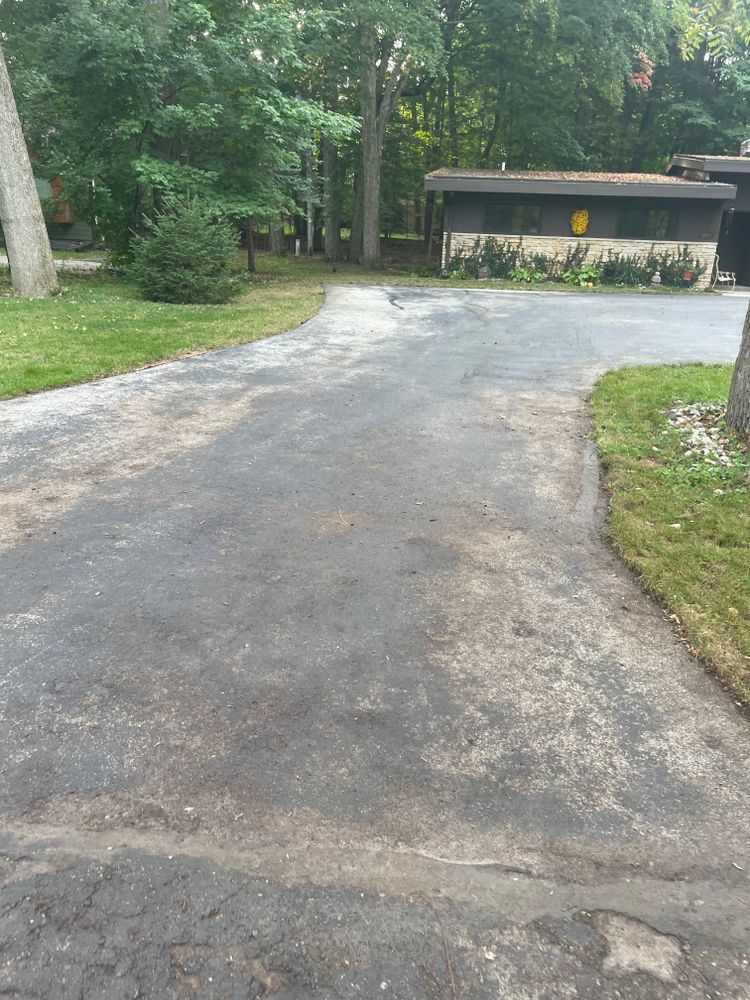 A driveway leading to a house in the woods