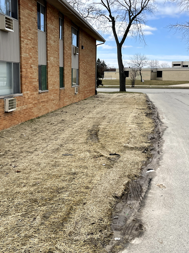 A brick building with a lot of grass in front of it