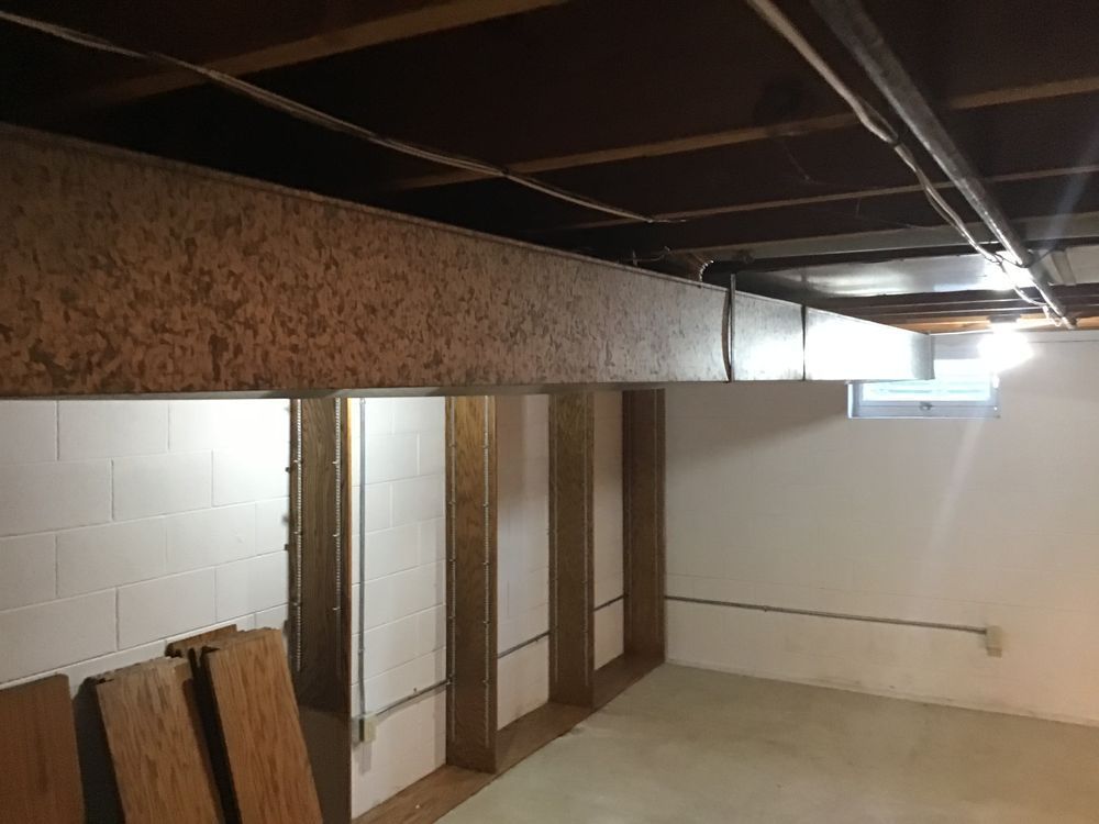 A basement with a wooden beam hanging from the ceiling