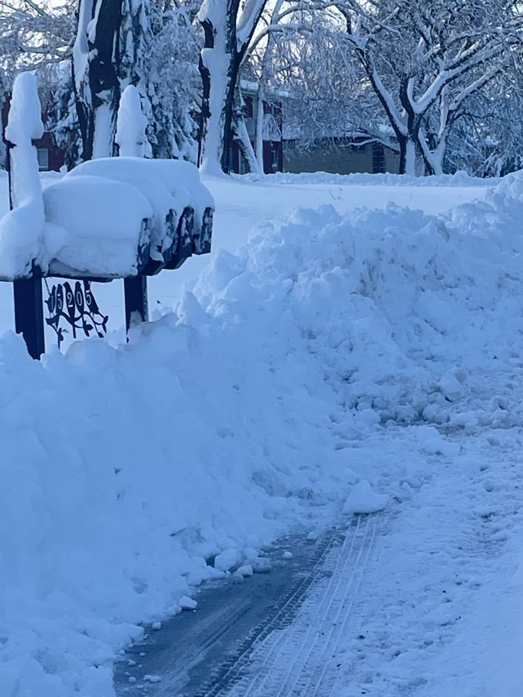 A snowy street with a mailbox covered in snow
