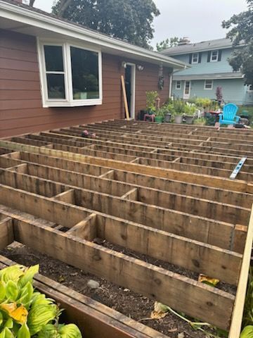 A wooden deck is being built in front of a house