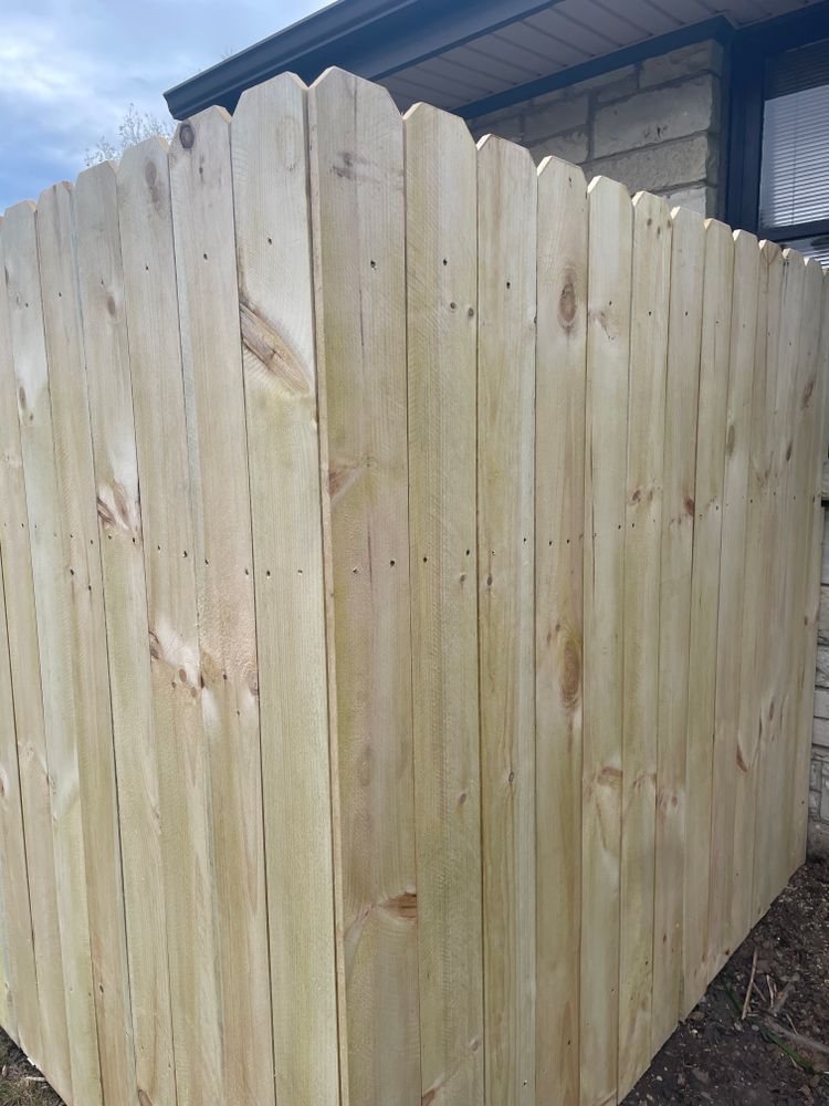A wooden fence is sitting in front of a house