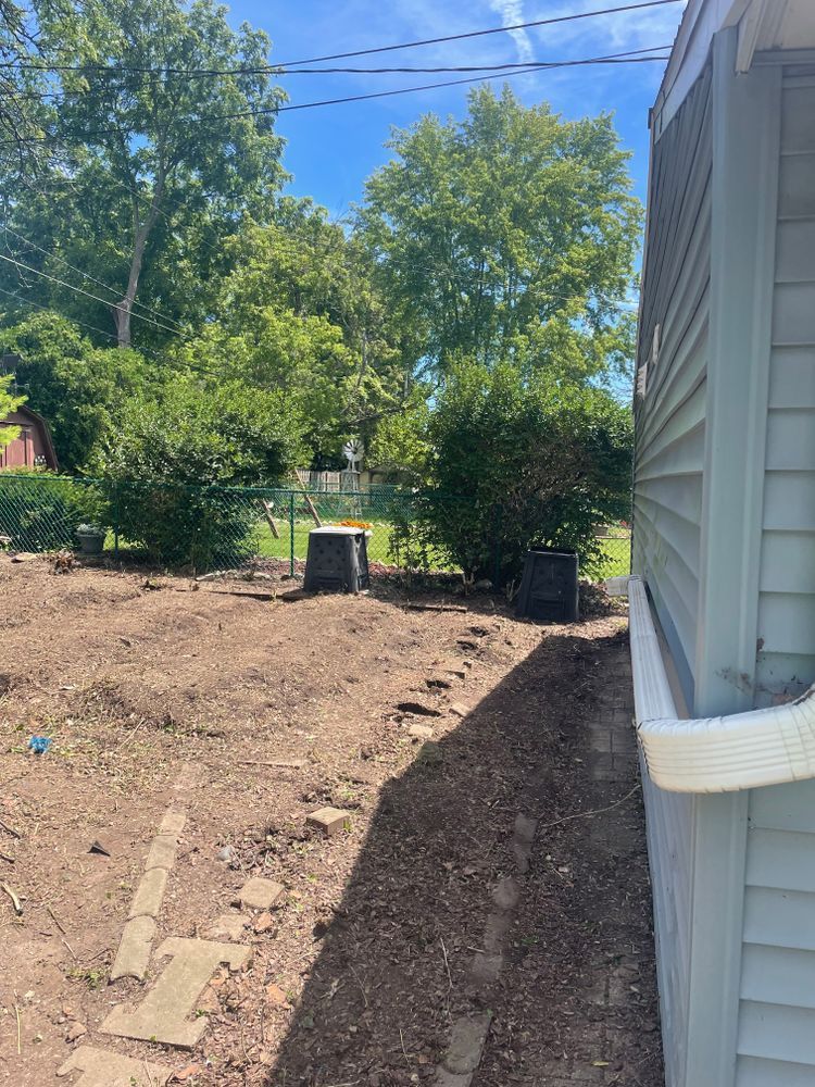 A house with a lot of dirt in front of it and trees in the background