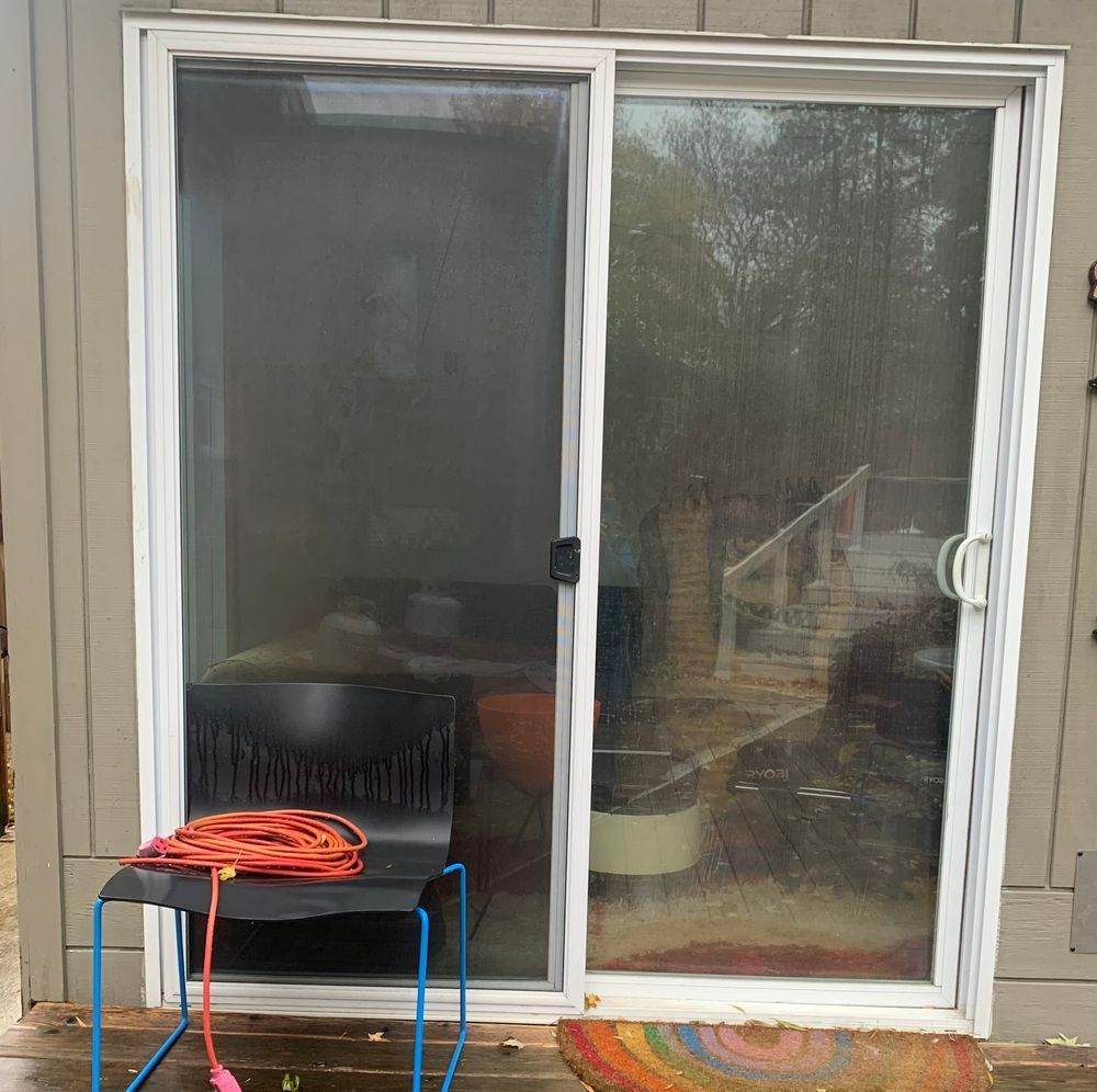 A sliding glass door with a chair in front of it