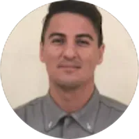 Um homem de camisa cinza está sorrindo em círculo.
