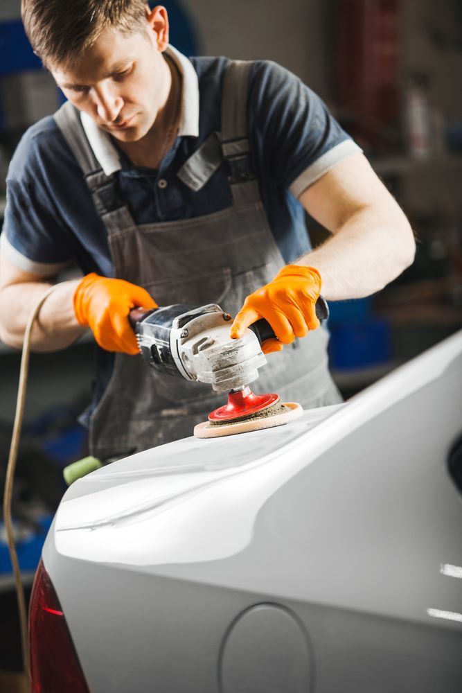 A Man is Polishing a Car With a Grinder — Smash Repairs In Wingham, NSW