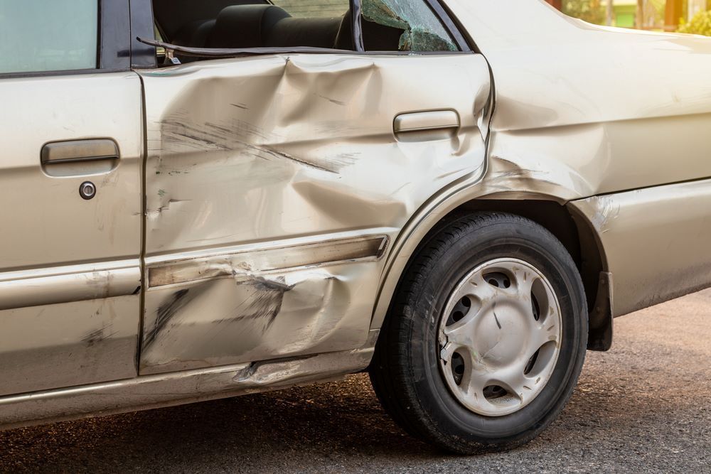A Car With a Damaged Side is Parked on the Side of the Road — Smash Repairs In Old Bar, NSW