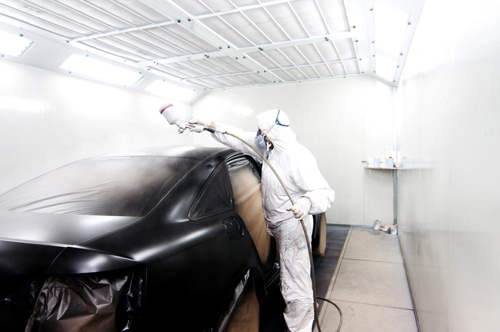 Worker Painting A Car Black — Smash Repairs In Taree, NSW