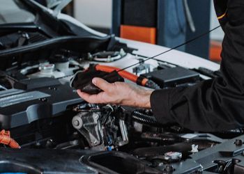 A man is working on the engine of a car.