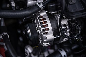 A close up of an alternator in a car engine.