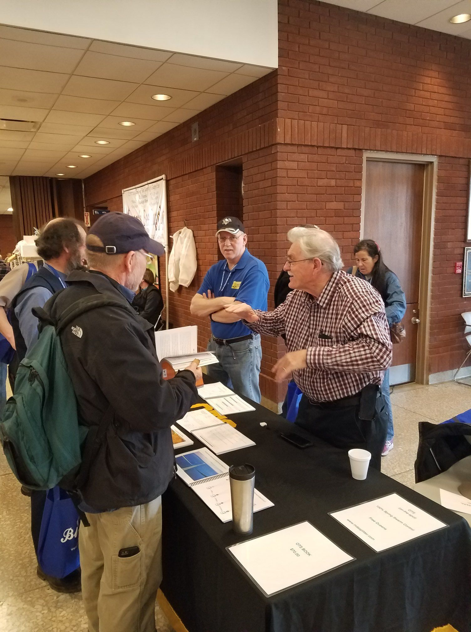 A group of men are standing around a table at a job fair.
