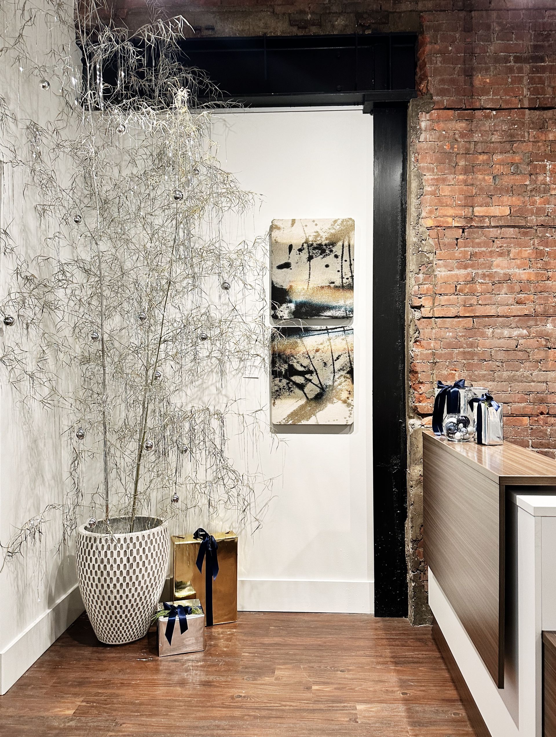 A room with a brick wall and a painting on the wall