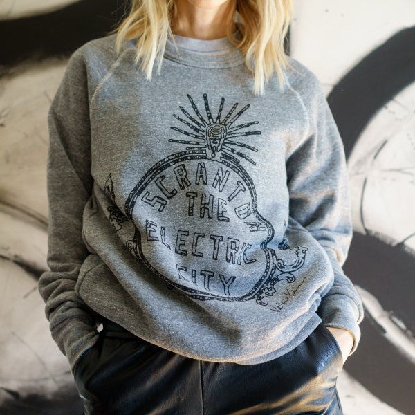 A woman wearing a grey sweatshirt that says scranton the electric city