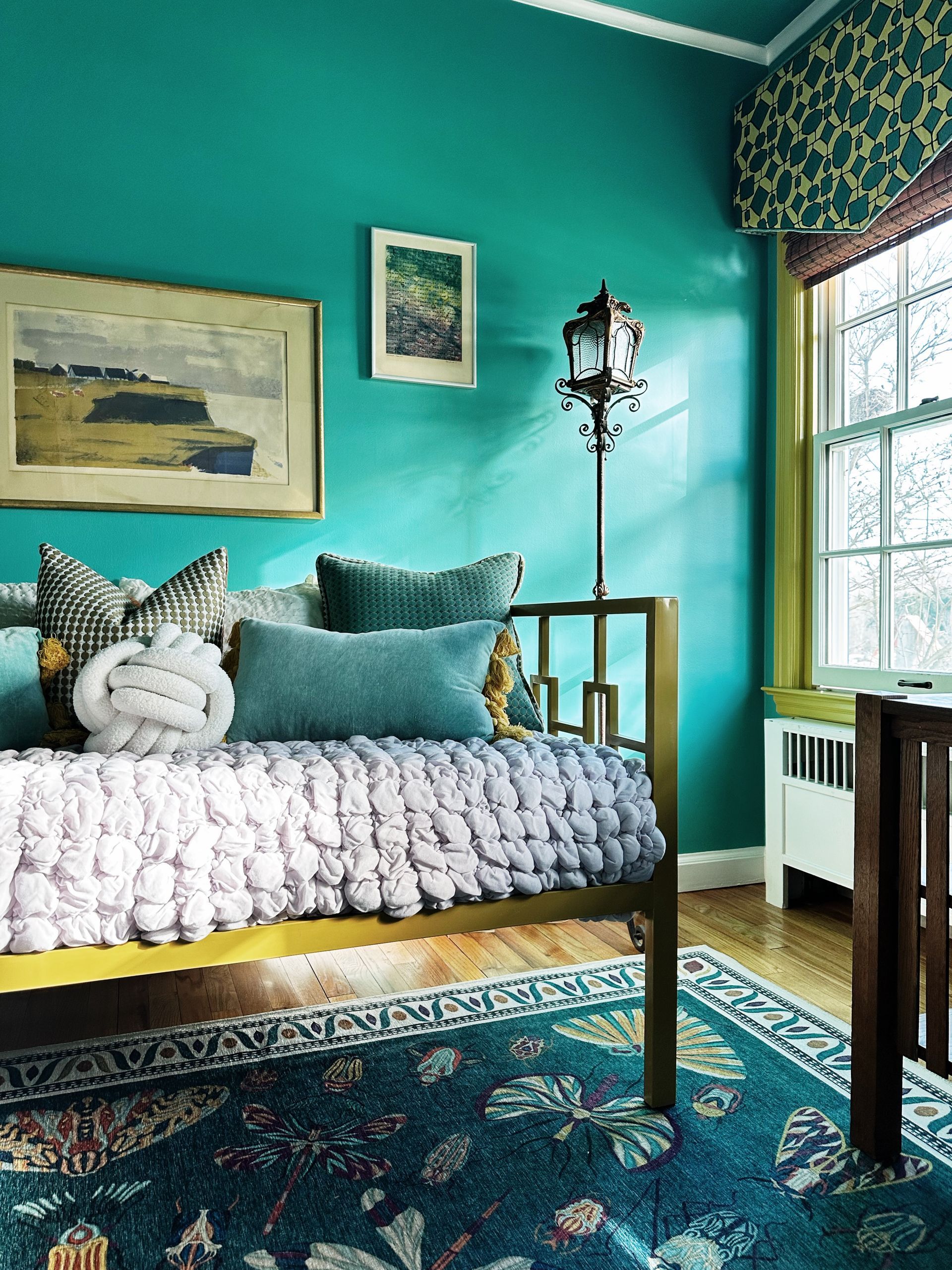A bedroom with blue walls and a day bed.