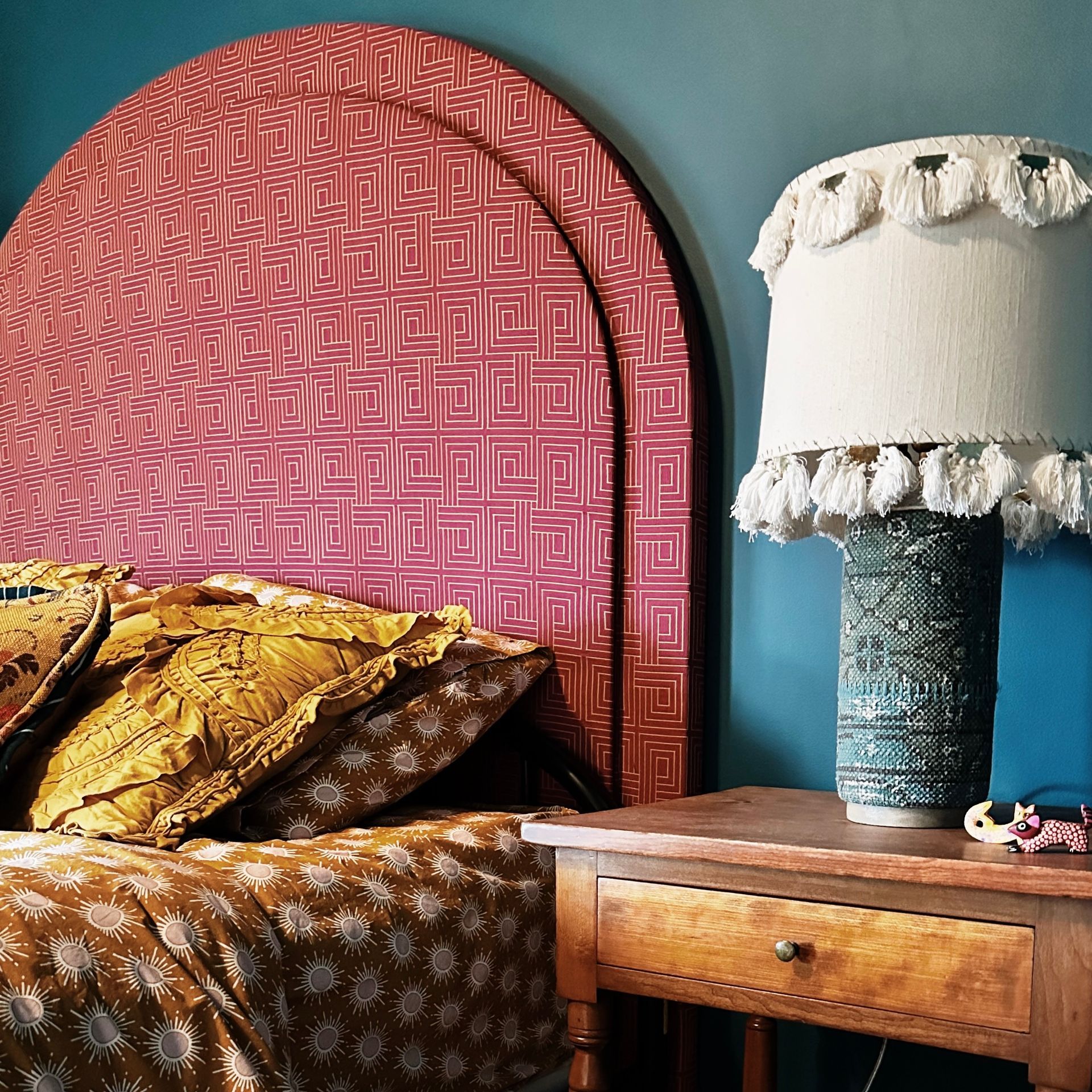 A bedroom with a bed and a lamp on a nightstand