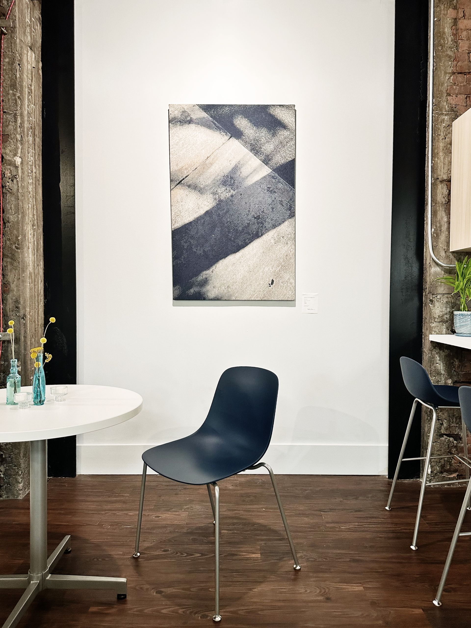 A room with a table and chairs and a painting on the wall