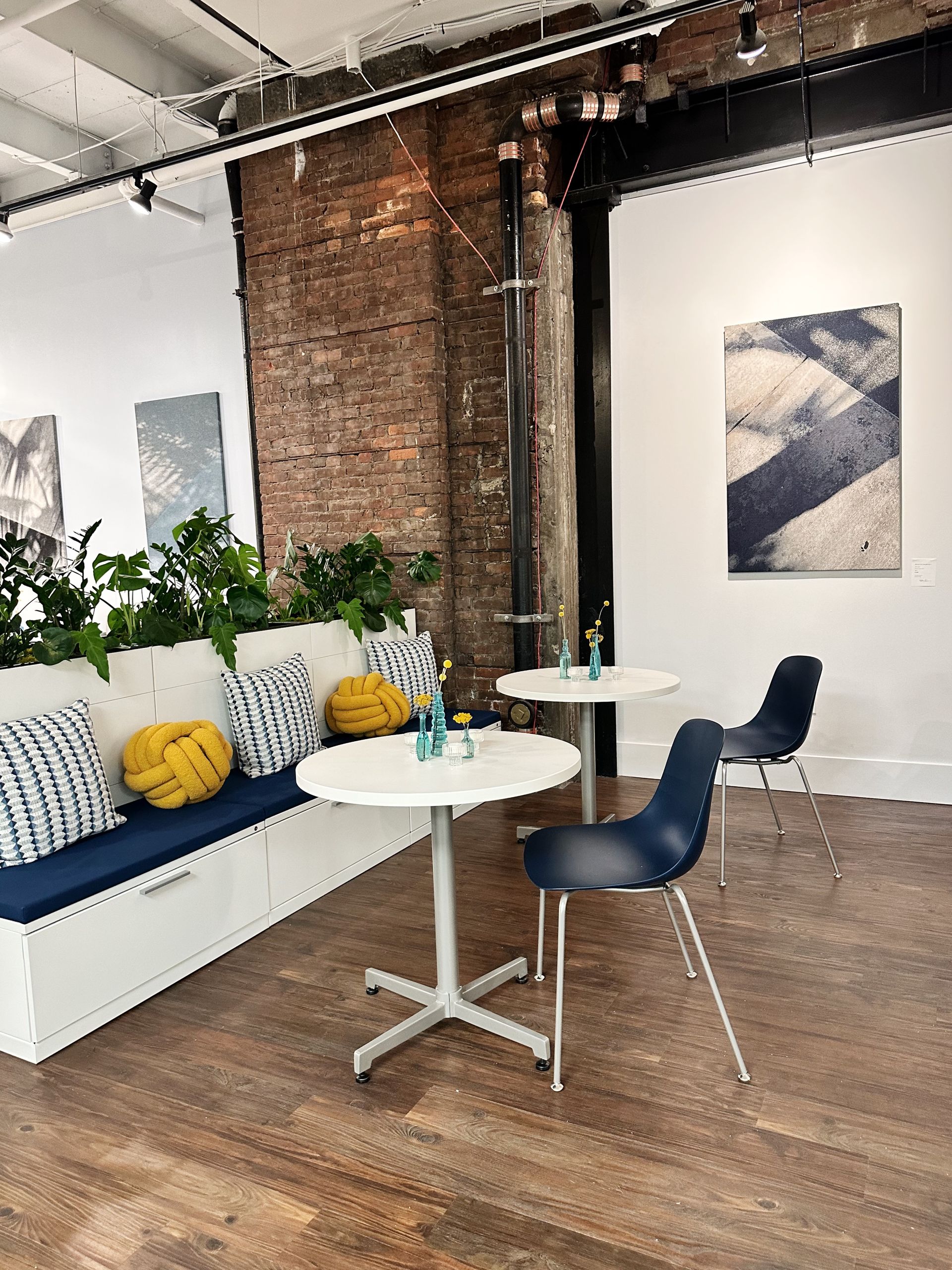 A room with tables and chairs and a brick wall.