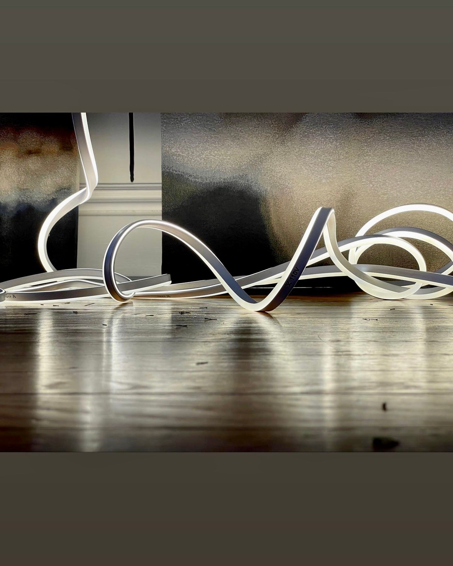 A bunch of wires are laying on a wooden floor.