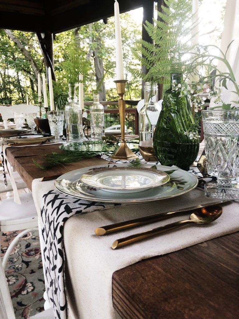 A table set for a dinner party with plates , utensils , and candles.