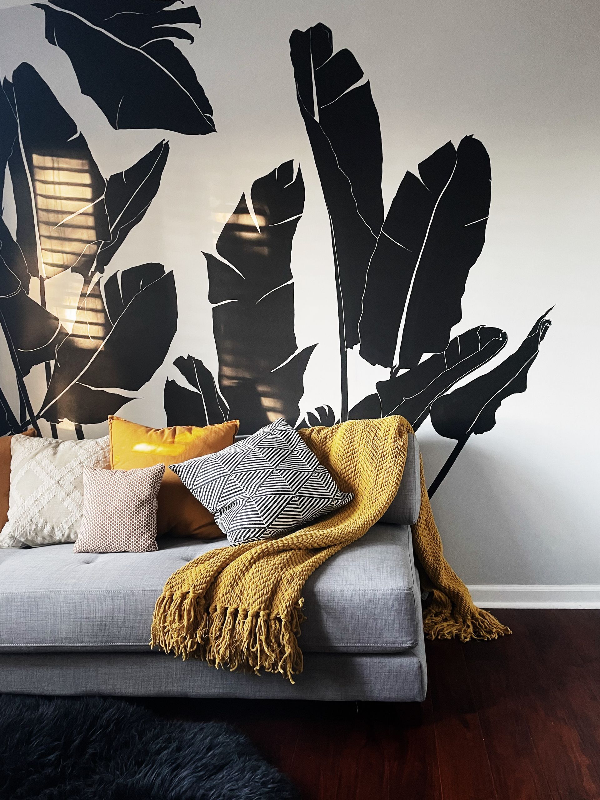 A couch with pillows and a yellow blanket on it