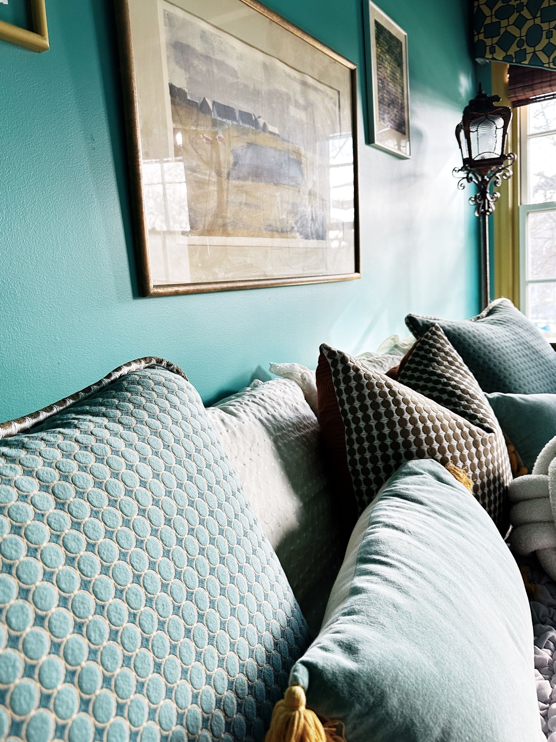 A couch with blue pillows and a picture on the wall