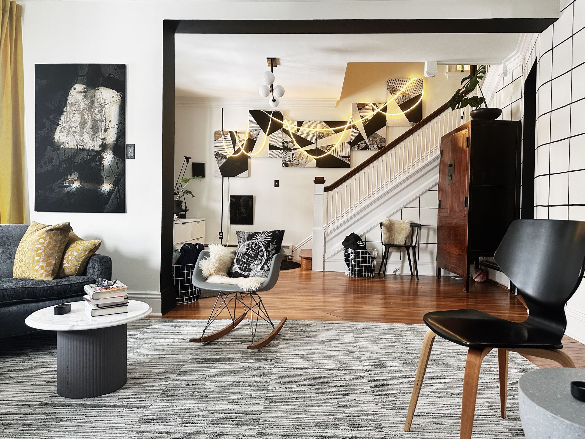 A living room with a rocking chair , couch , table and chairs.
