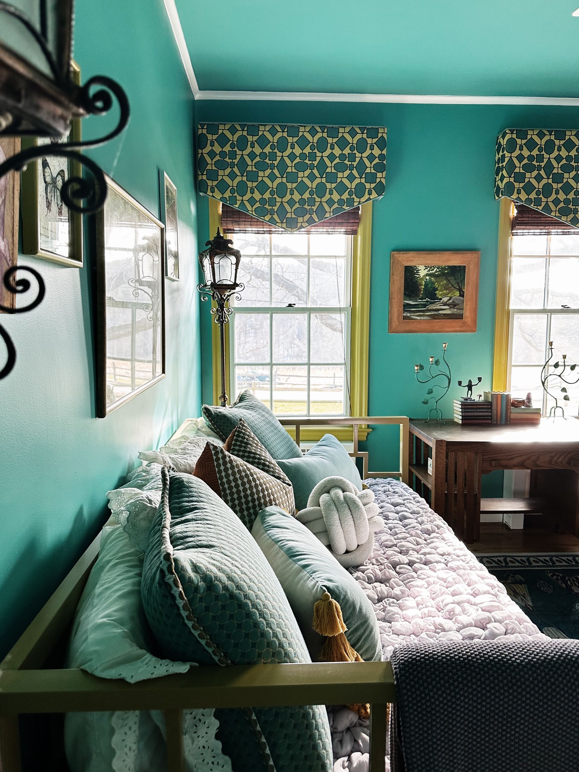 A living room with blue walls and a couch with pillows on it