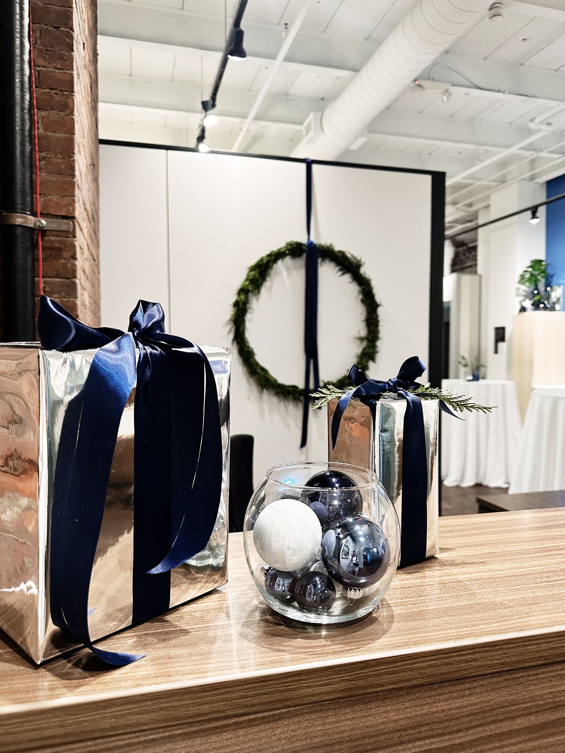 A wooden table with a bowl of blueberries and a wreath on it