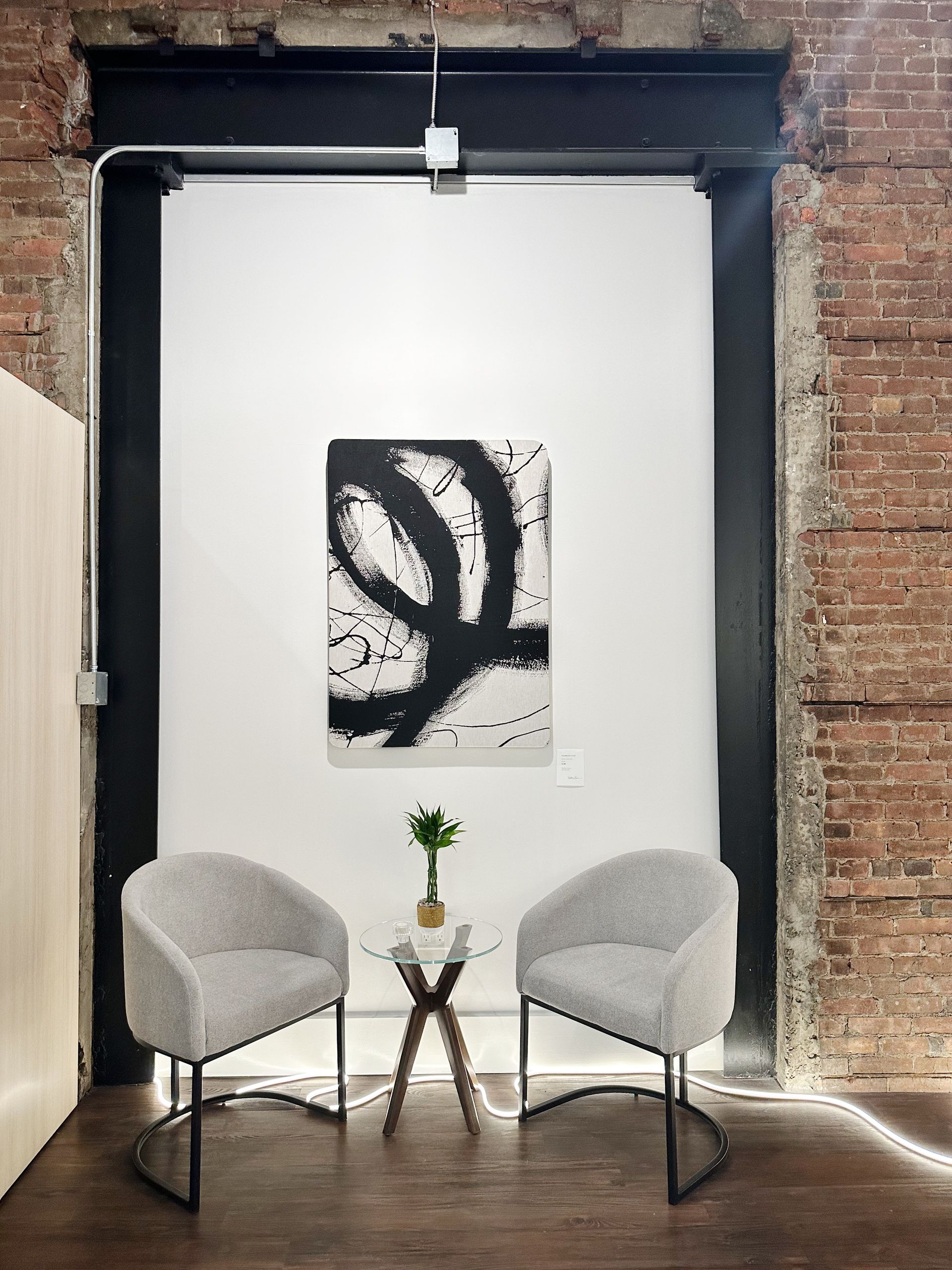 Two chairs and a table in a room with a brick wall.