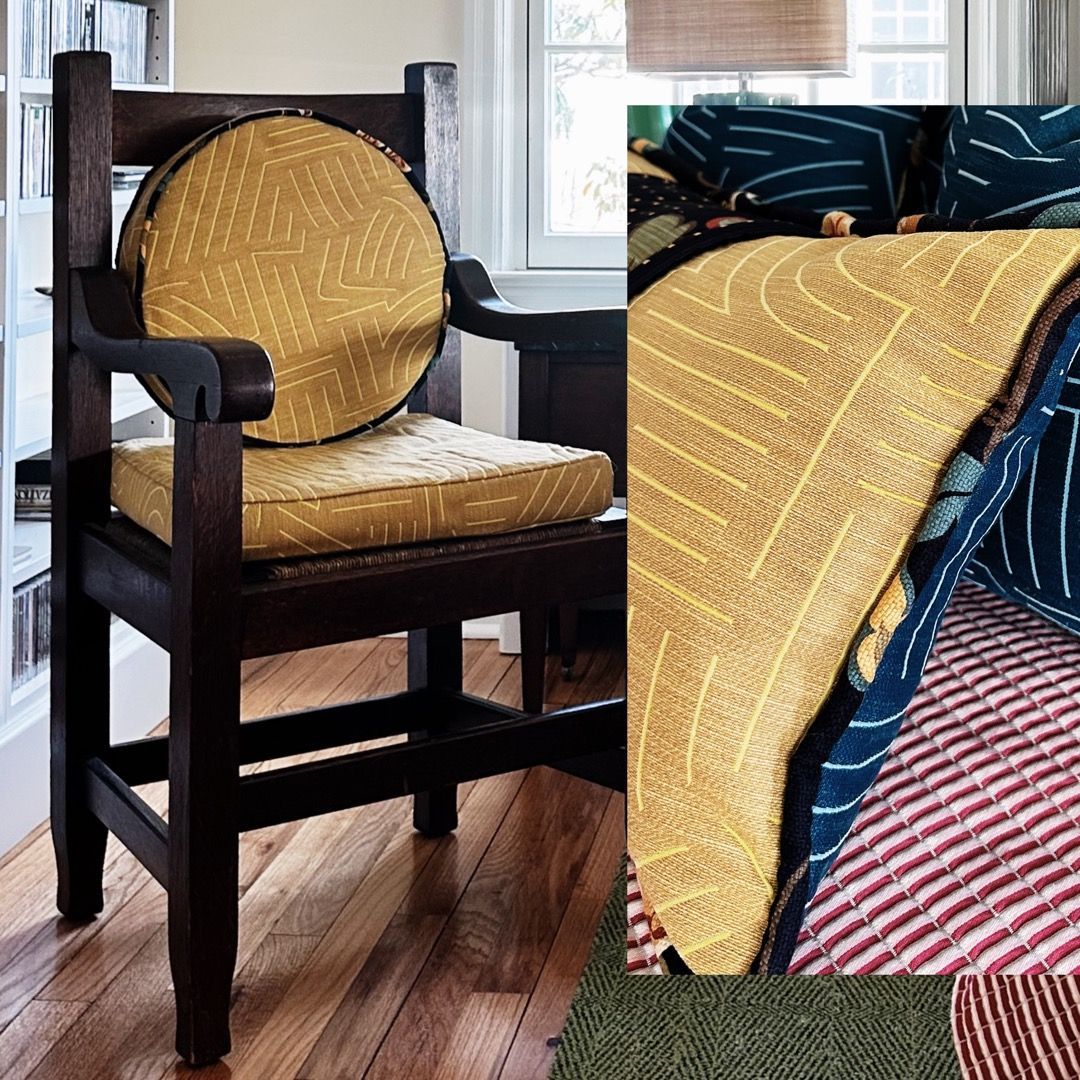 A chair with a yellow cushion sits next to a bed