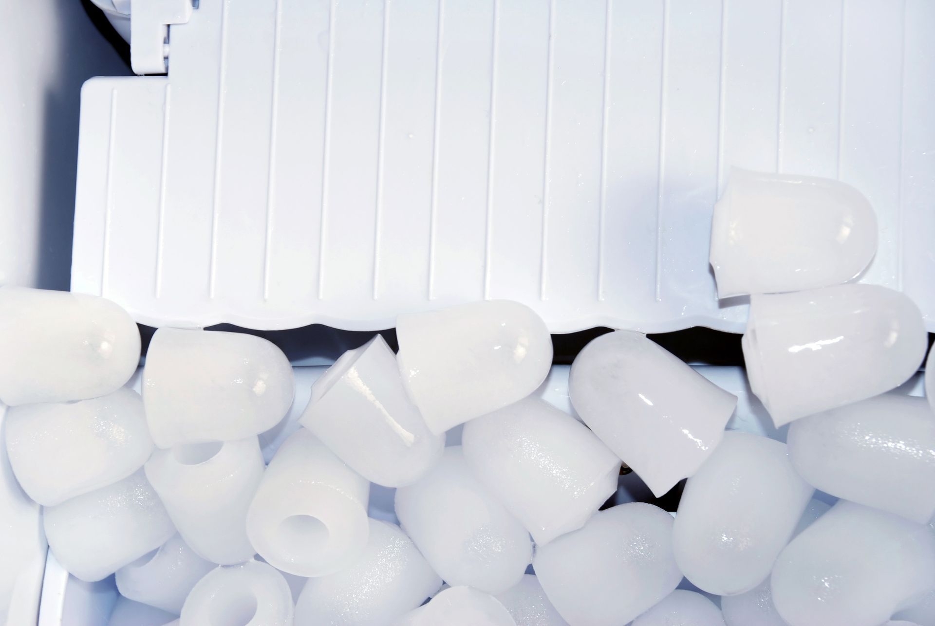 A pile of white ice cubes in a container
