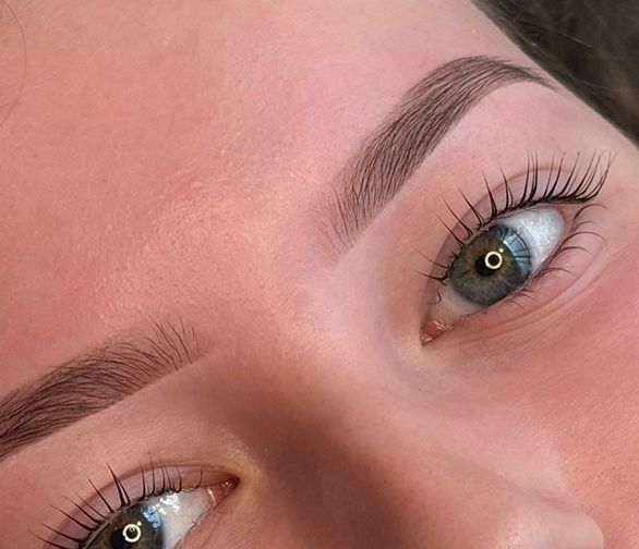 Een tennisracket en een bal liggen op een tennisbaan.