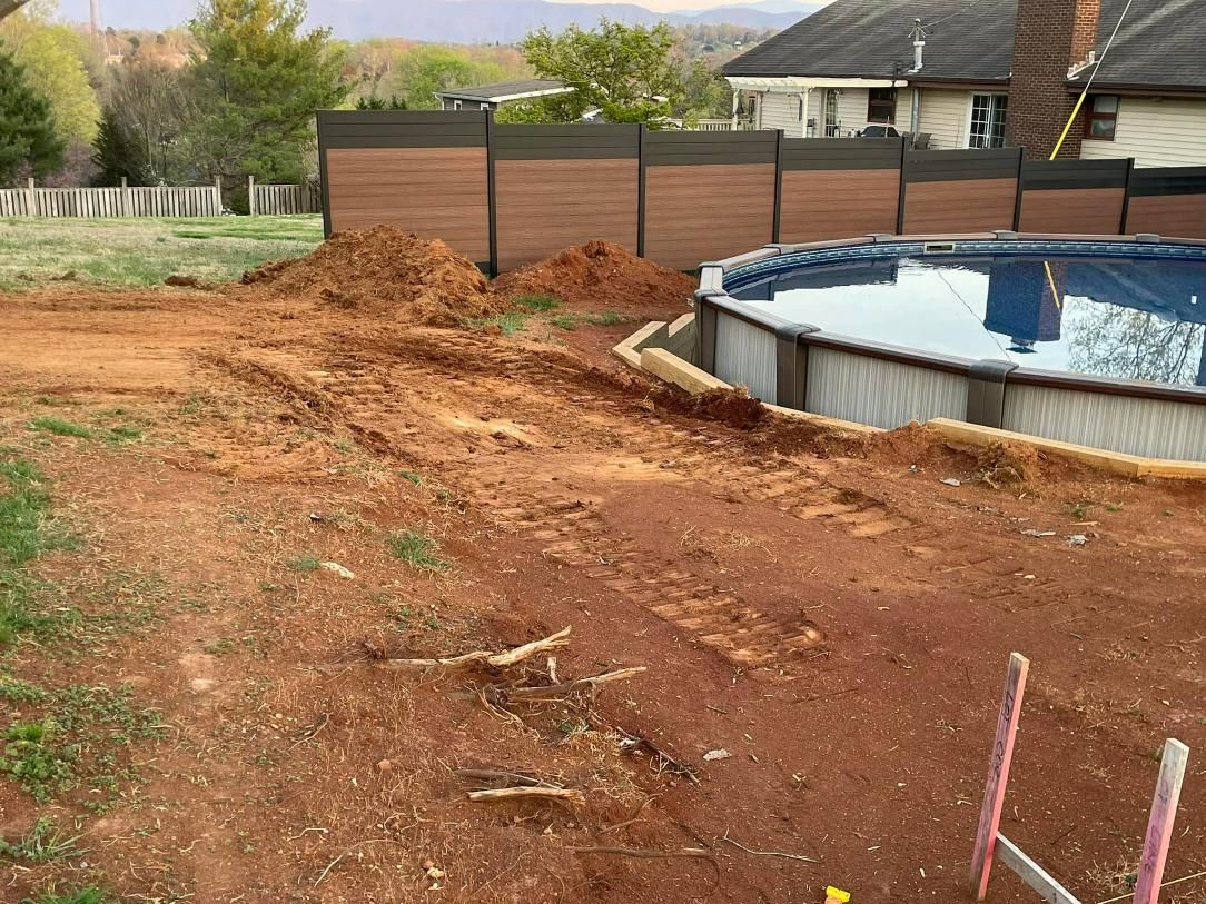 Brown dirt yard with above-ground pool and a partially built brown fence.