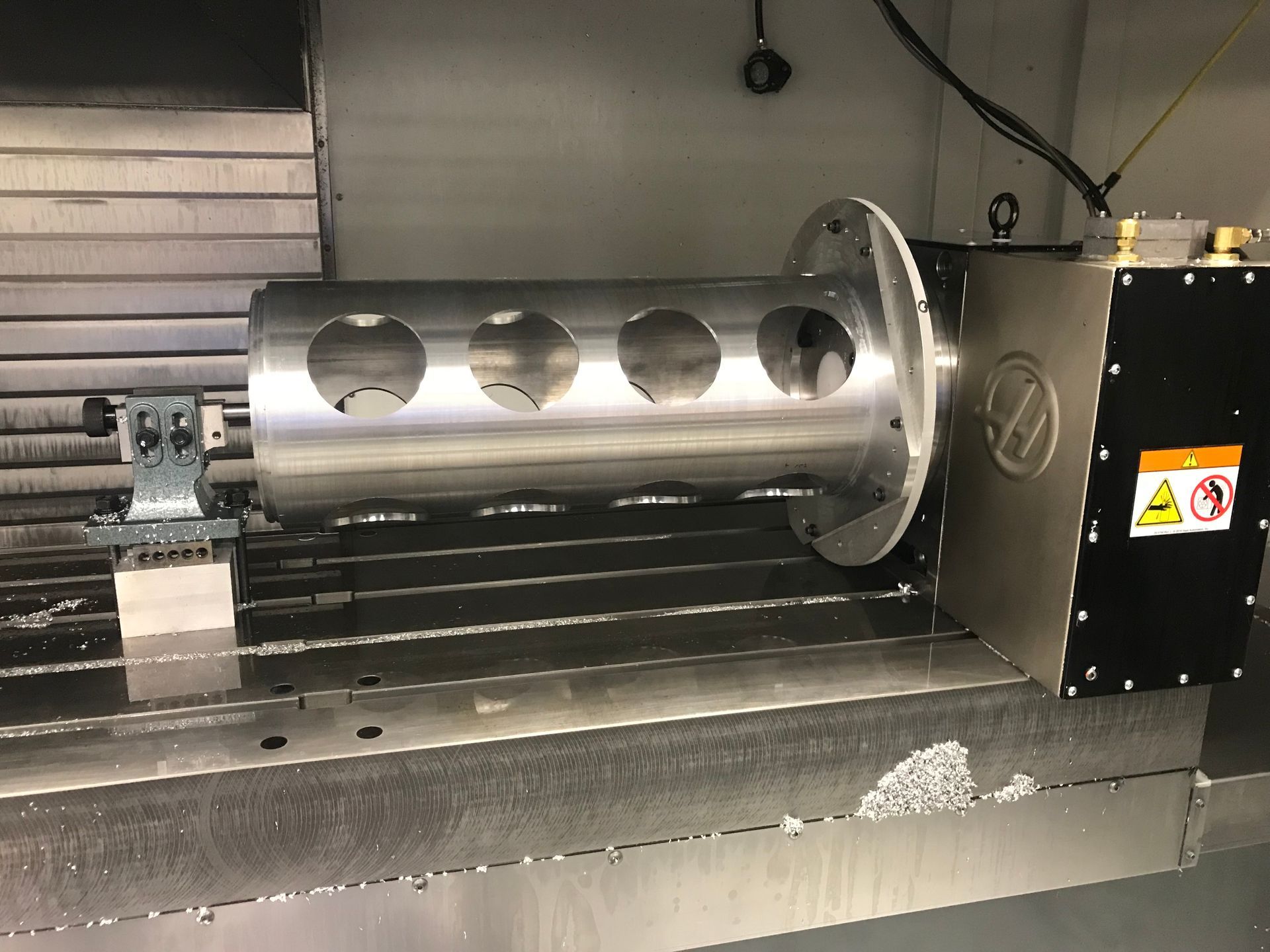 A stainless steel pipe is being cut on a machine.