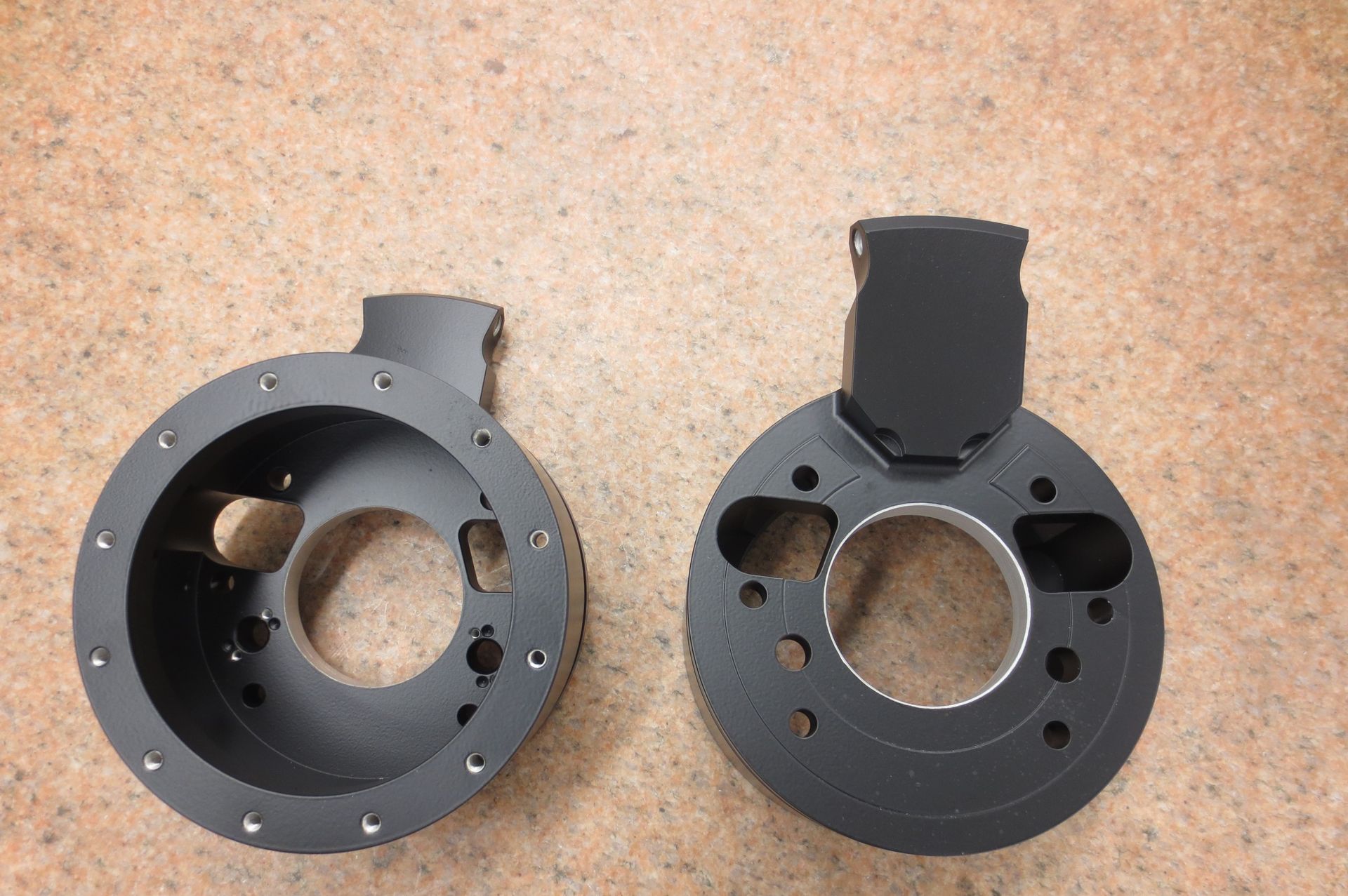 Two black circles with holes in them are on a table