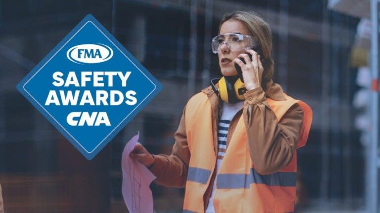 A woman in an orange vest is talking on a cell phone.