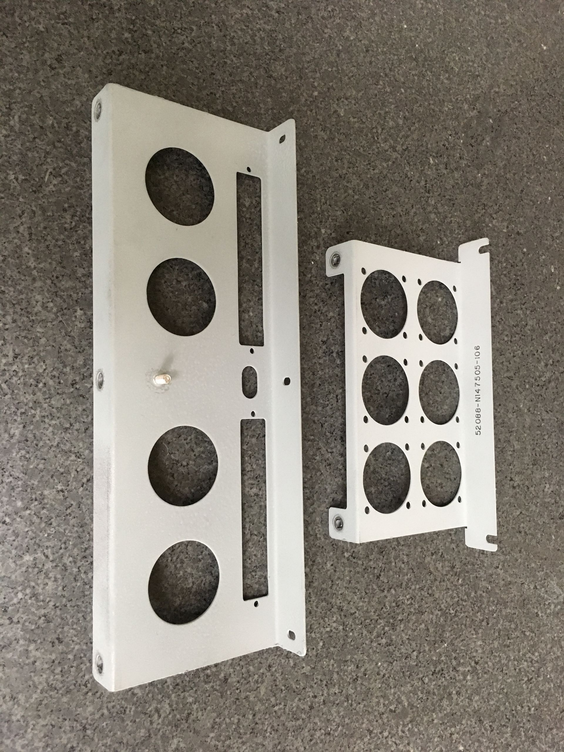 Two white plates with holes in them are sitting on a carpet.