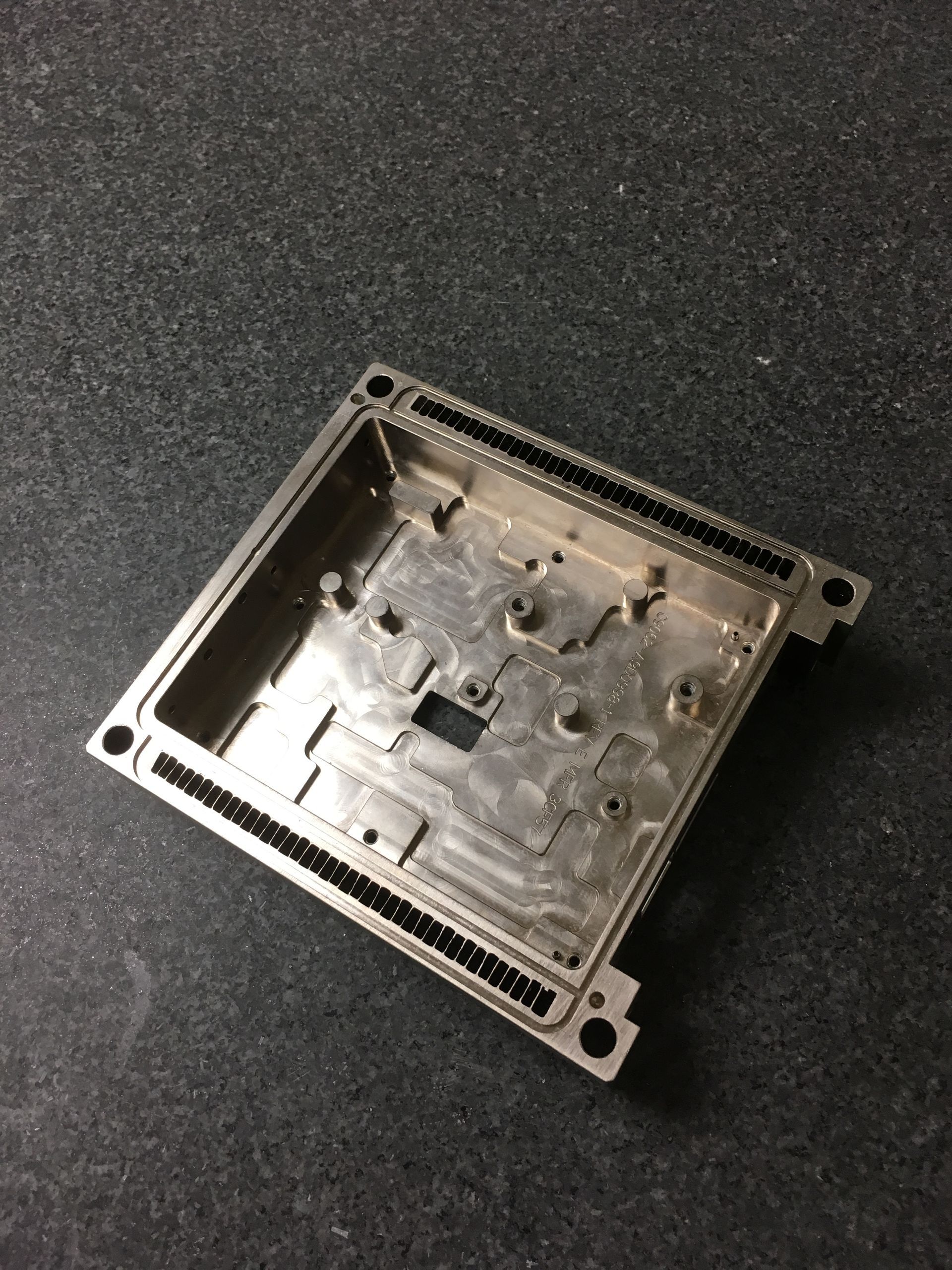 A small metal box is sitting on a black surface.