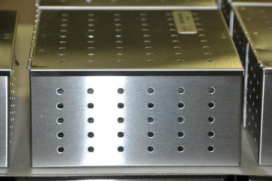 A row of stainless steel boxes with holes in them