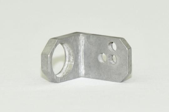A metal bracket with holes in it is sitting on a white surface.