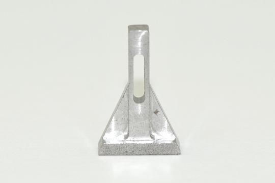 A metal object with a hole in the middle is sitting on a white surface.