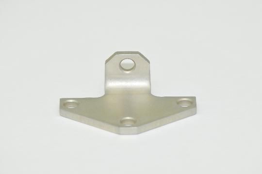 A metal bracket with holes in it is sitting on a white surface.