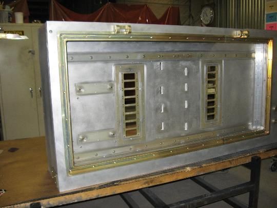 A large metal box is sitting on a wooden table