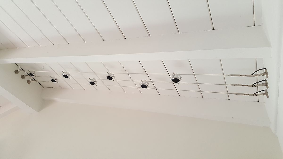 White ceiling with exposed wiring, light fixtures, and recessed lighting holes.