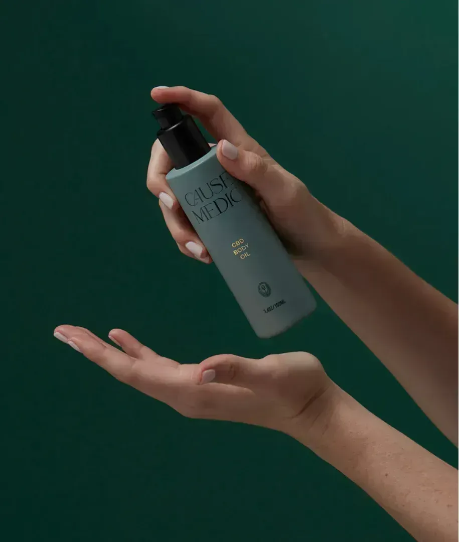 Hands dispensing product from a teal bottle with black pump.
