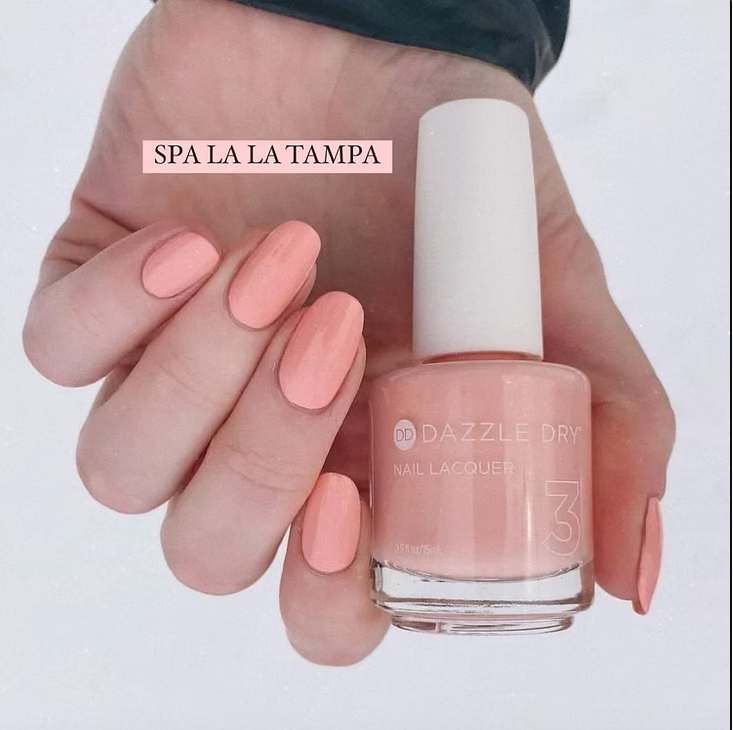 Freshly manicured nails shine in a soft peach hue with Dazzle Dry polish, a perfect finish.
