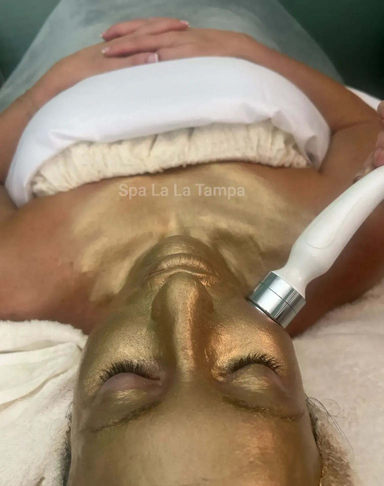 Woman receiving a facial with a gold mask.