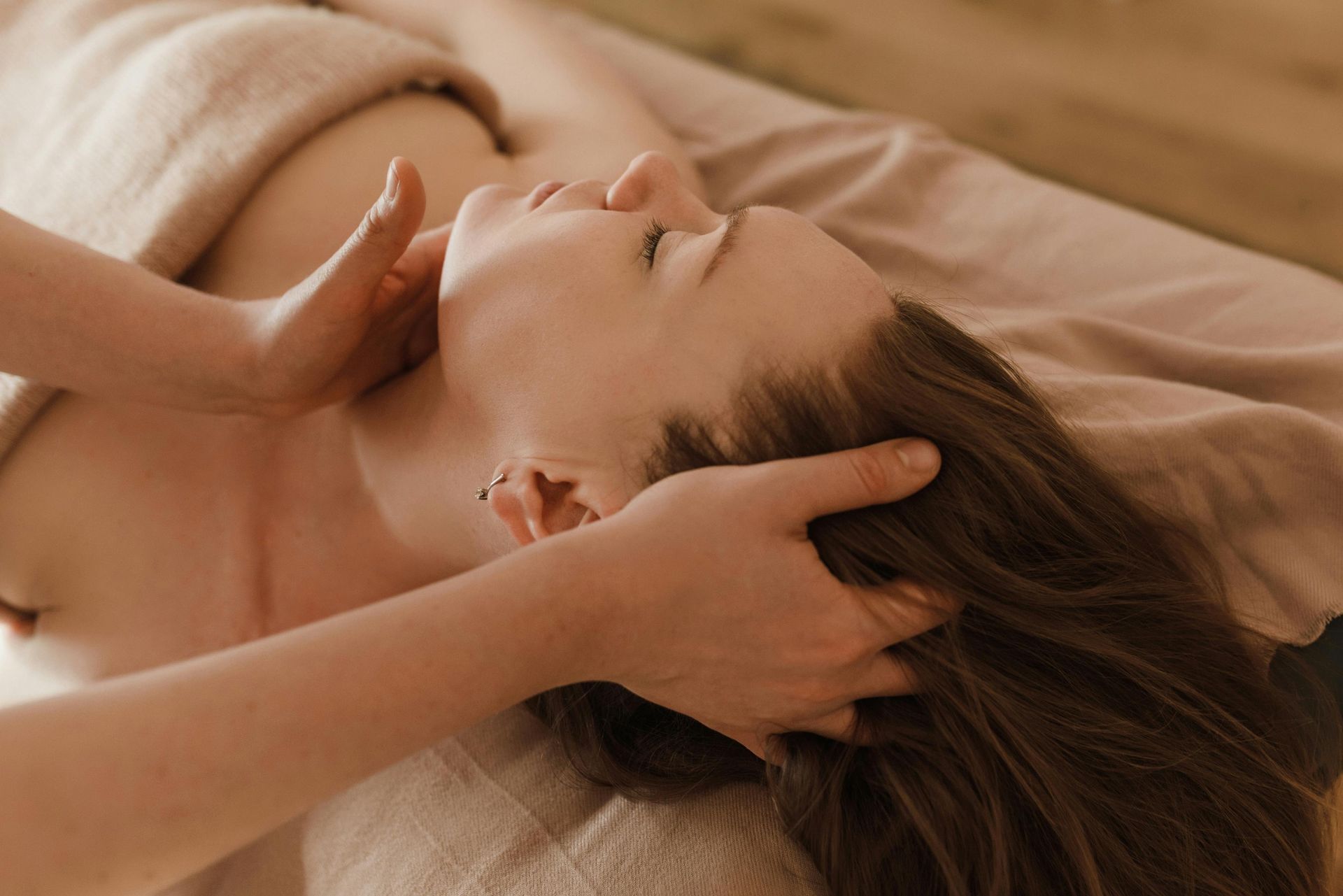 Woman receiving a head and neck massage on a massage table.