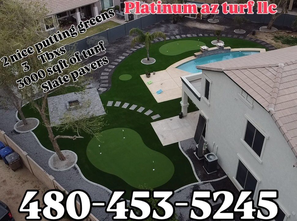 An aerial view of a residential backyard with two putting greens, artificial turf, slate pavers, a pool, and a fire pit.